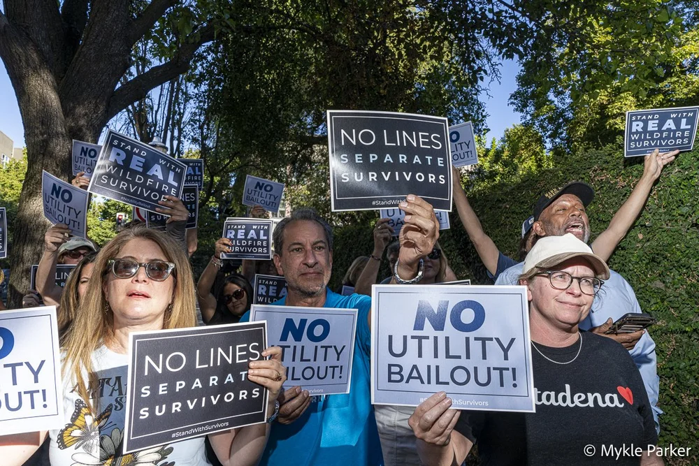 Survivors holding No Utility Bailout signs in Sacramento