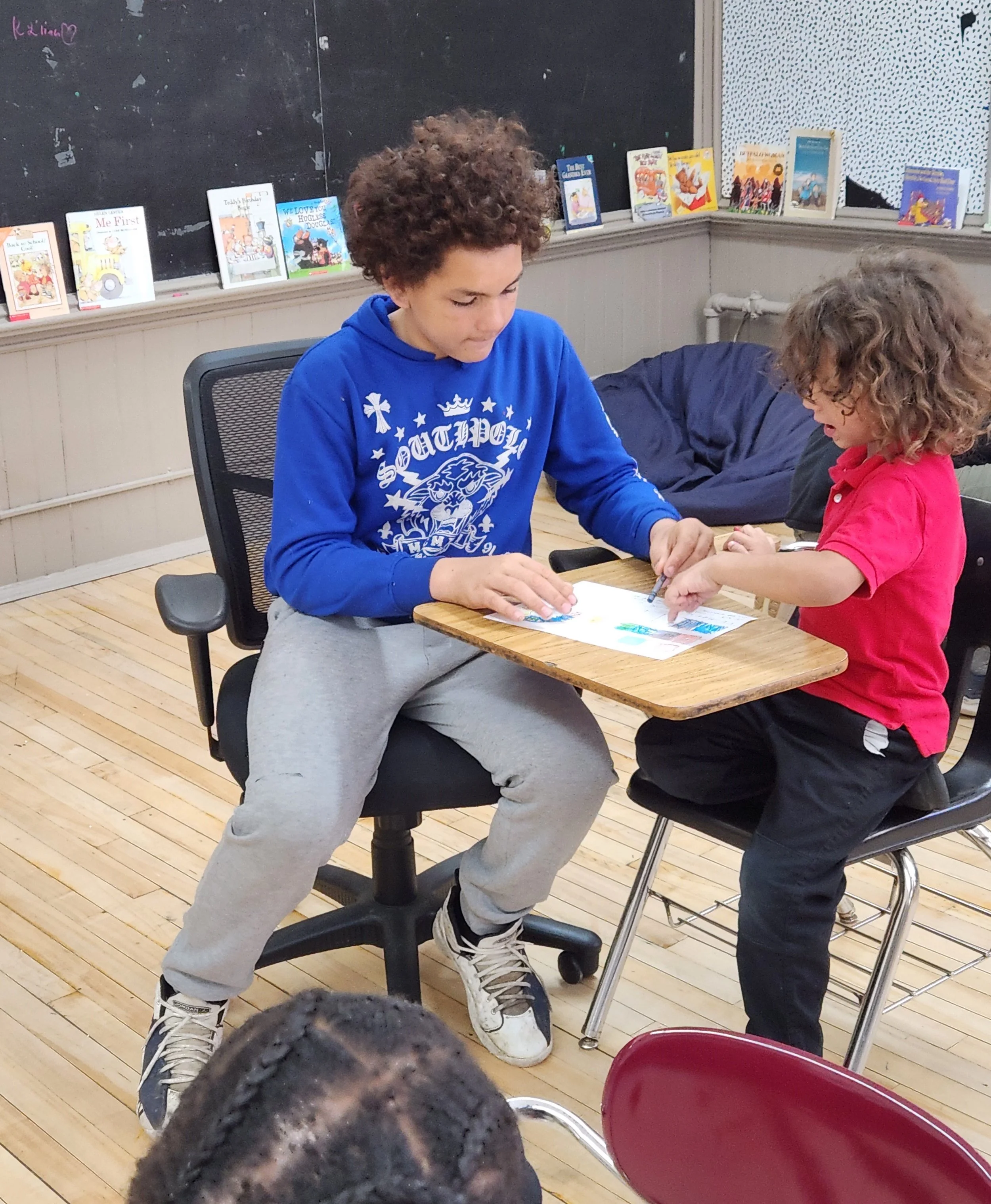 Two students working together at a classroom desk