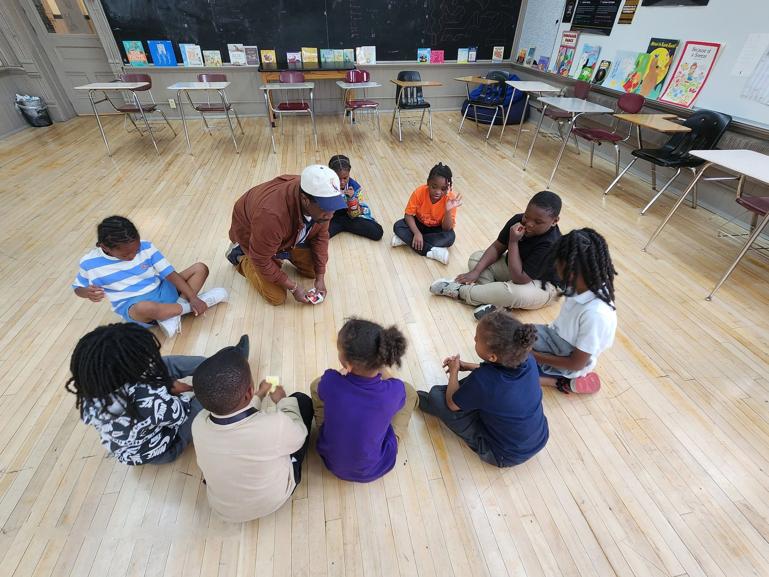 Staff member leading students through a seated circle discussion