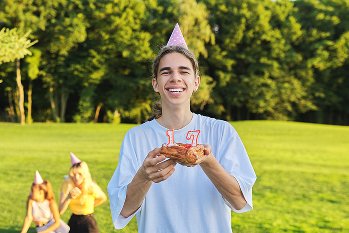 Friends around a birthday cake on a lawn