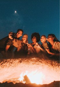 Friends gathered around a campfire at night