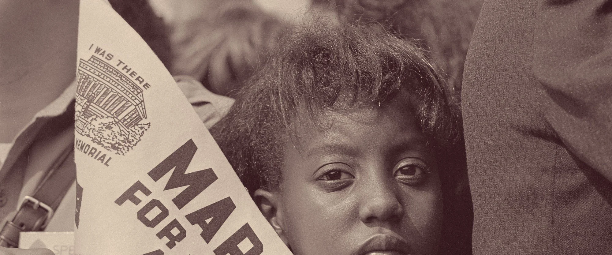 A young girl holds a "March for Jobs" banner at the 1963 March on Washington for Jobs and Freedom