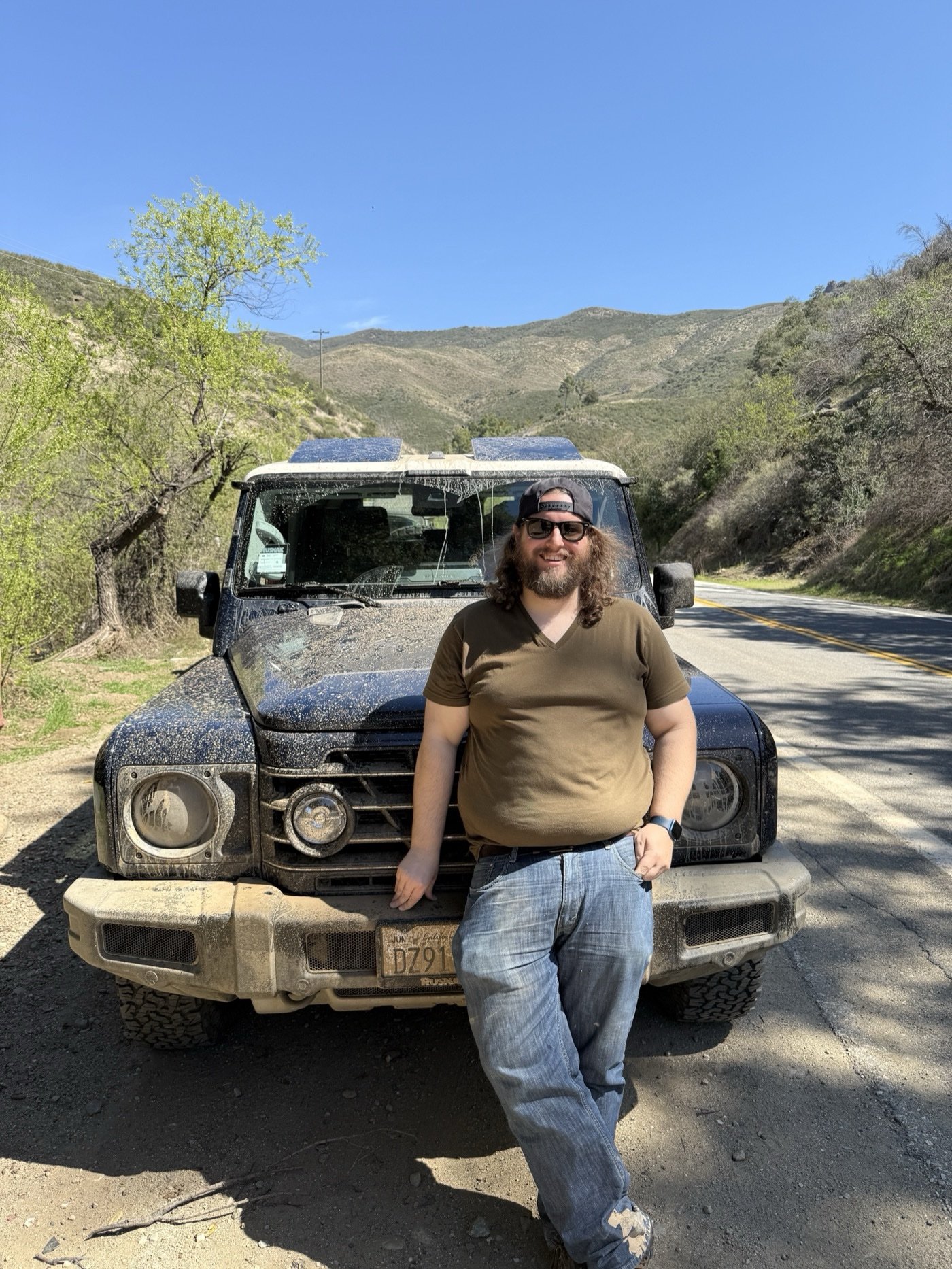 Travis with a mud-covered INEOS Grenadier after a trail day
