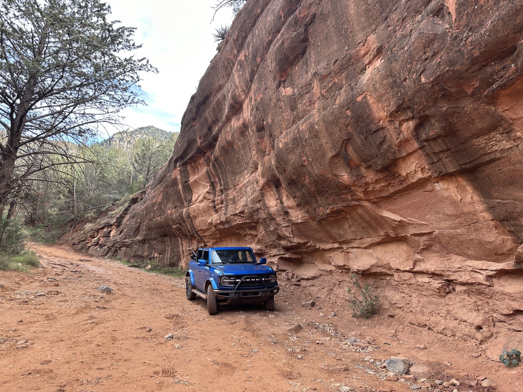 Ford Bronco with the top down on a red rock canyon trail