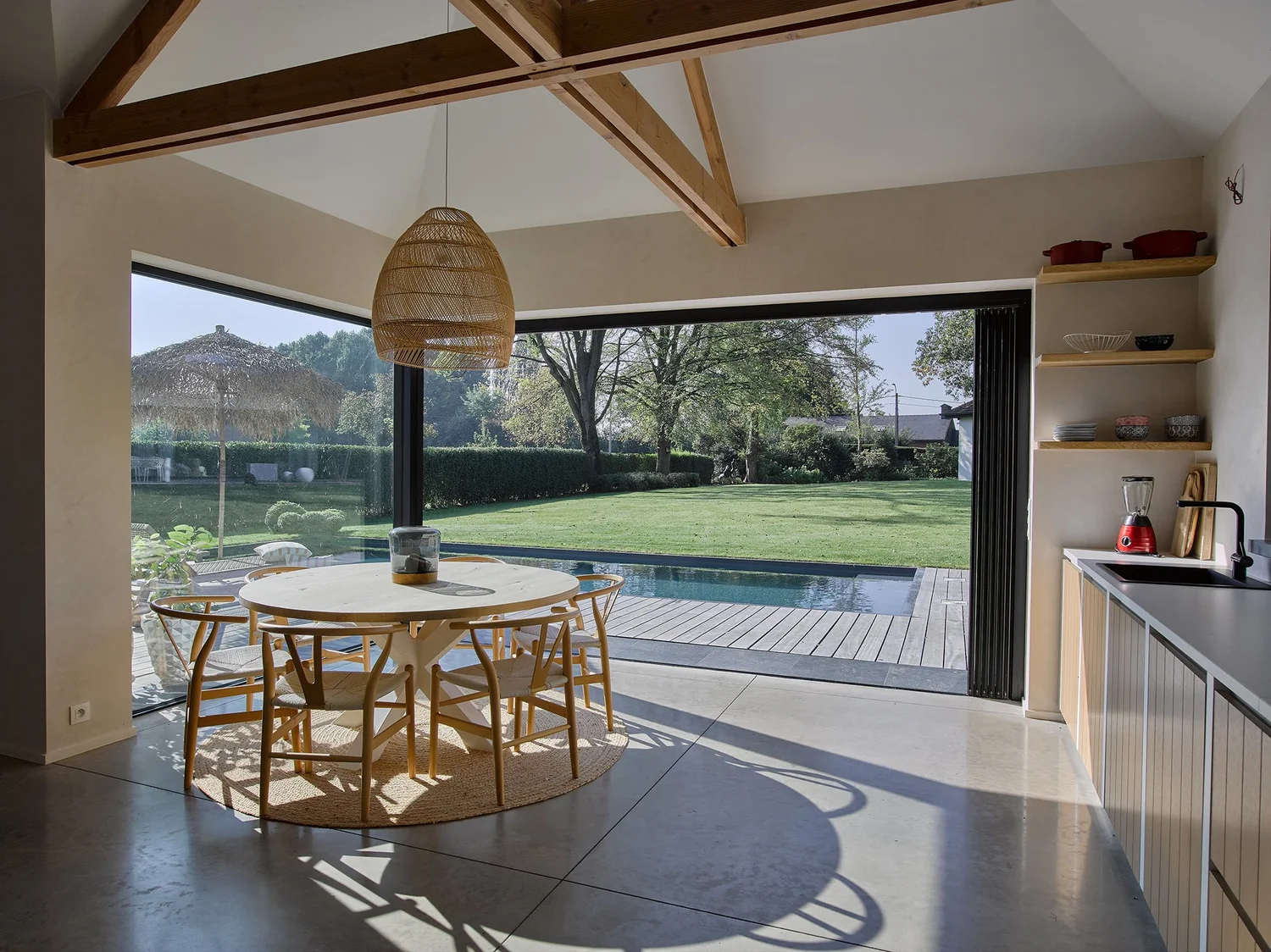 Keuken in een poolhouse in Sint-Gillis, de glazen wand staat open met zicht op het zwembad