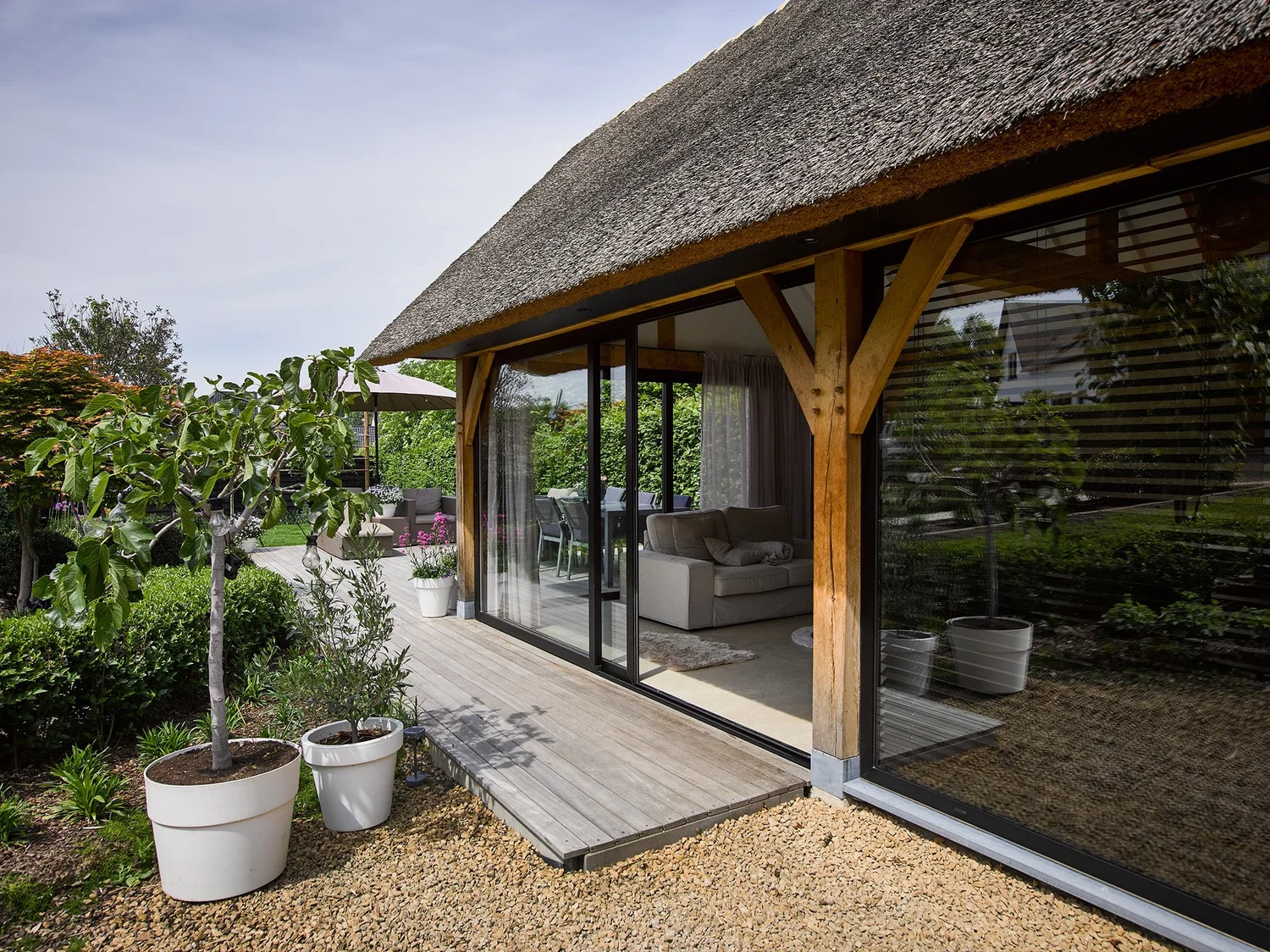 Bijgebouw met rieten dak in Bilzen, afgesloten met een glazen schuifwand met dubbel glas