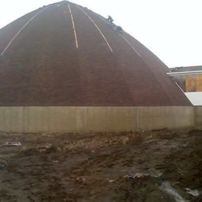 Installers shingling a salt storage dome