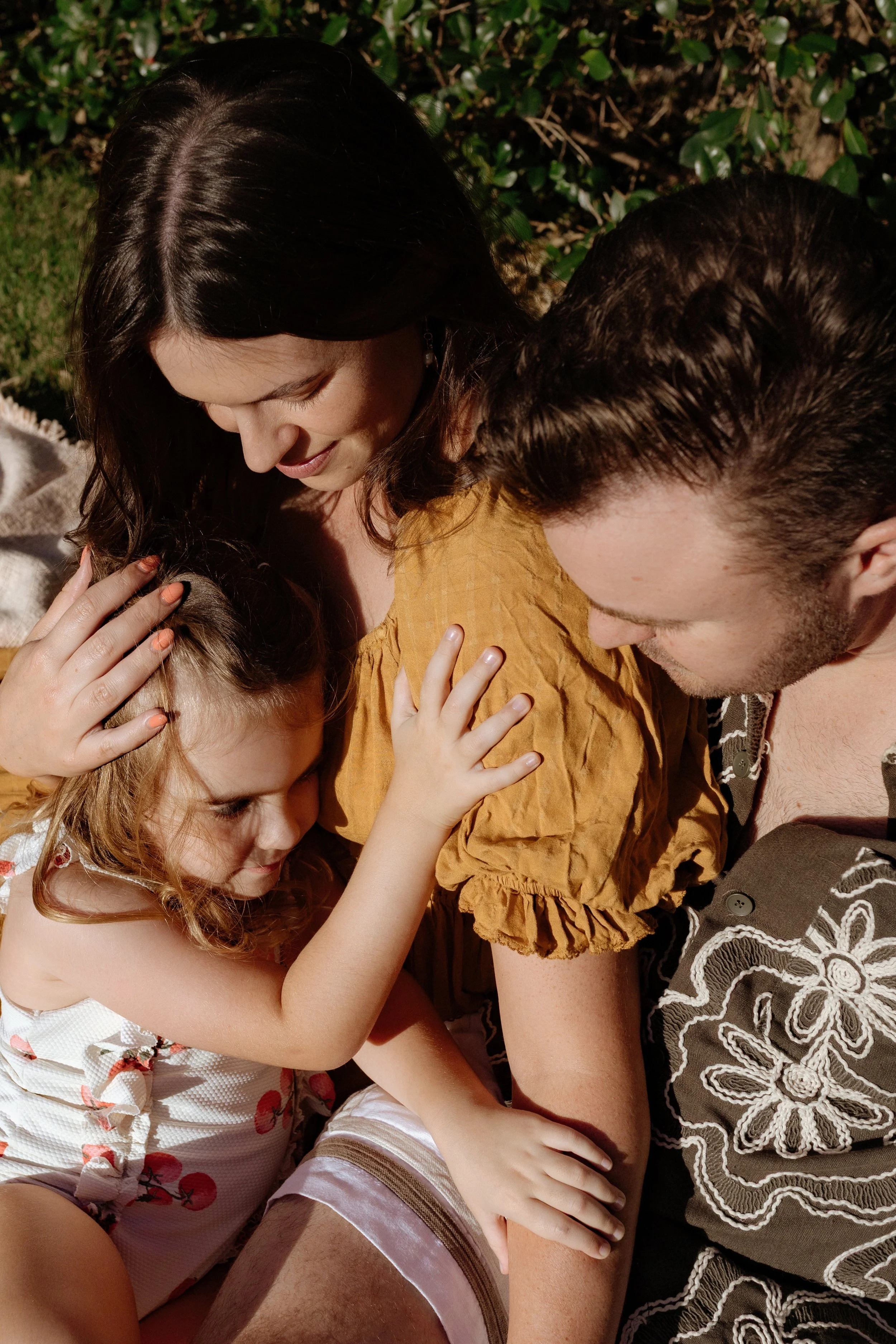 A family embracing outdoors, photographed by Bridget Wood