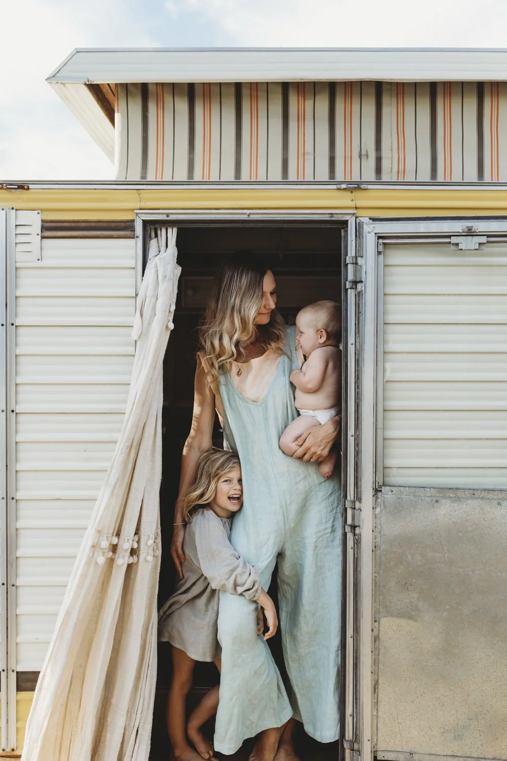 Mother and children beside a caravan