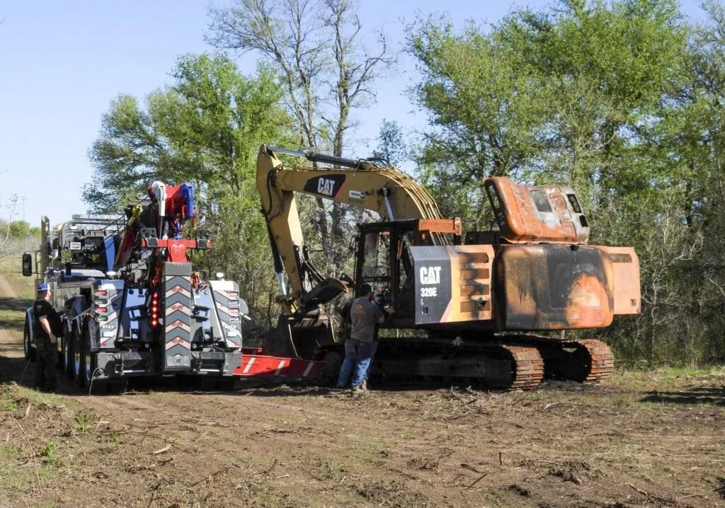 SAS Road Solutions transporting heavy construction equipment on a specialized trailer in Central Texas