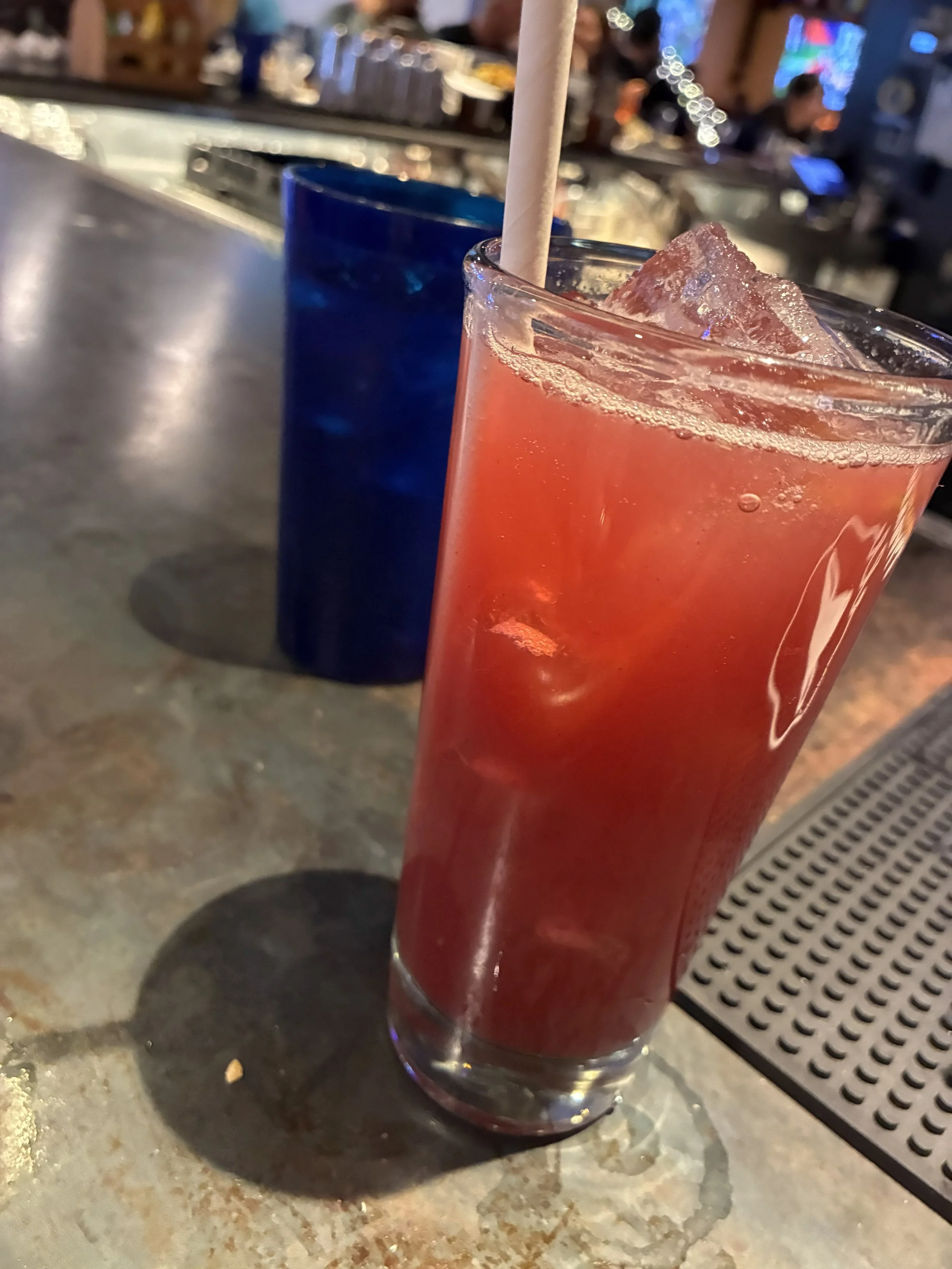 A red cocktail on a bar.