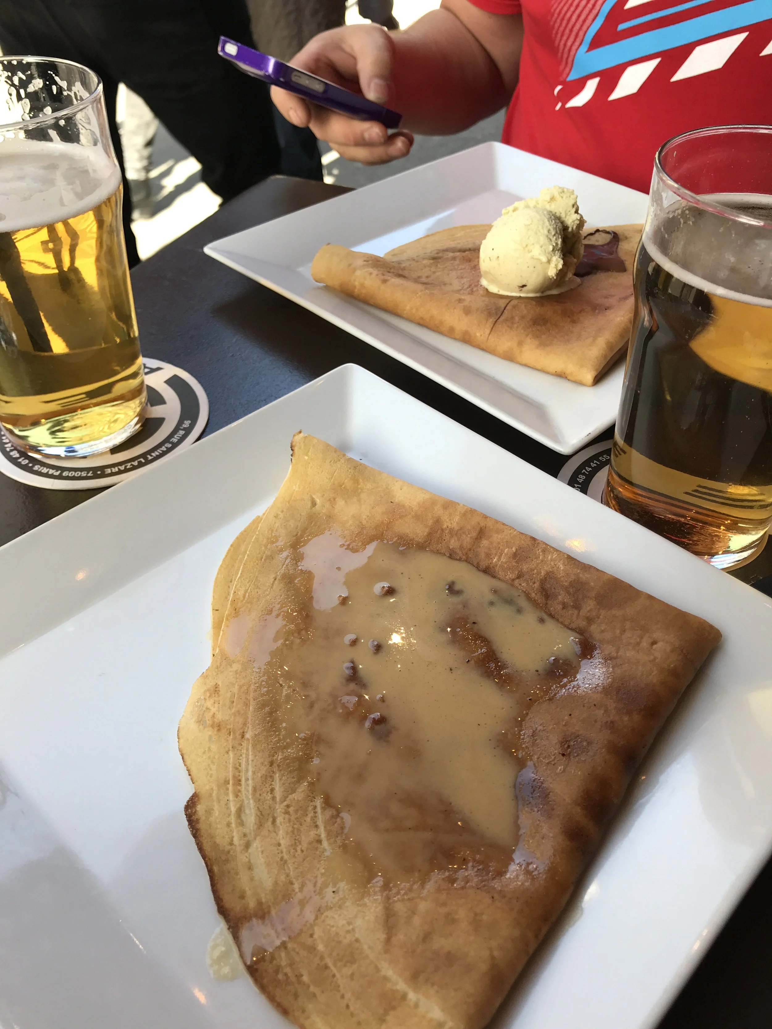 Crêpes and beer on a café table.