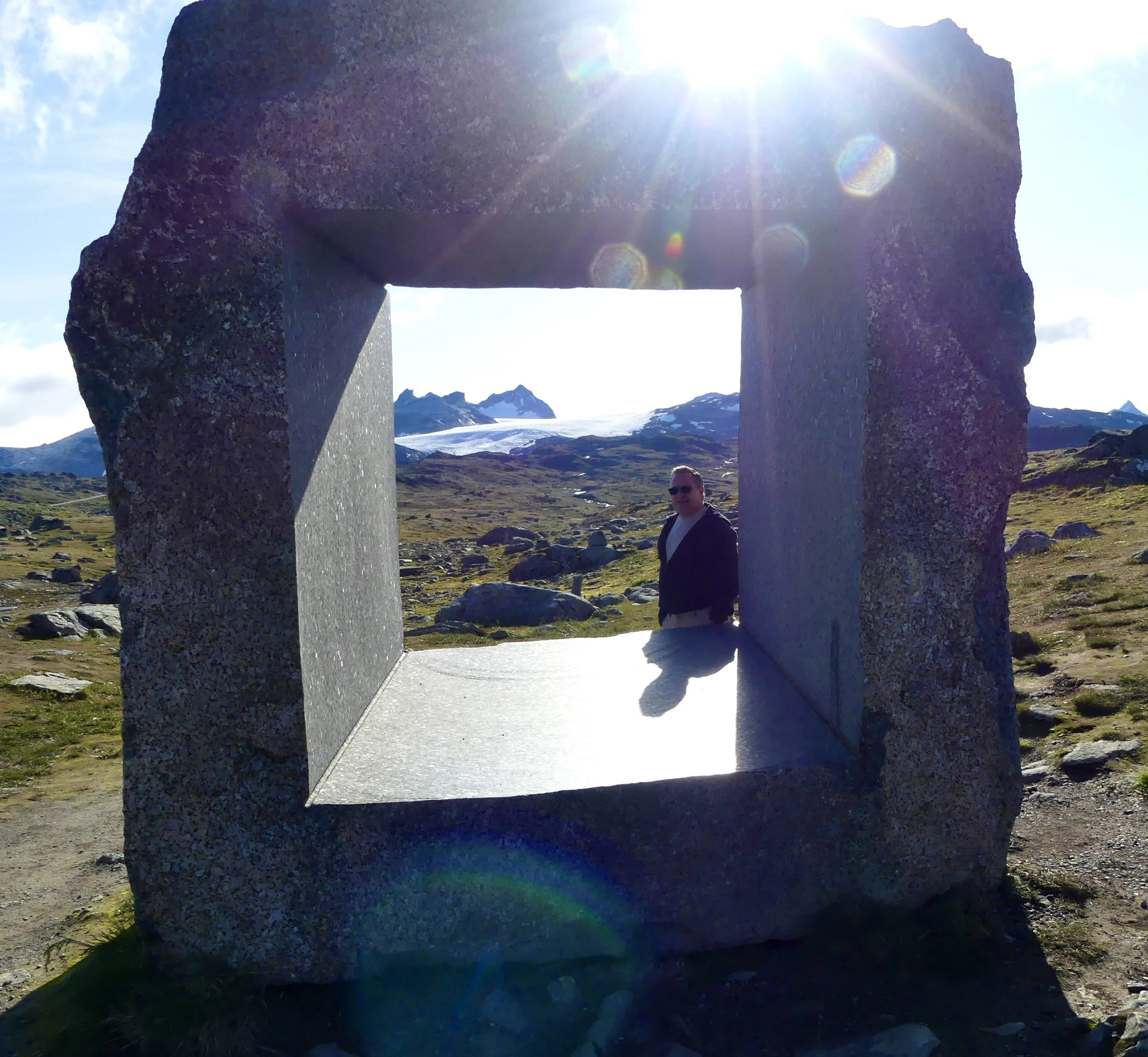 A stone window frames a view over a glacier valley.