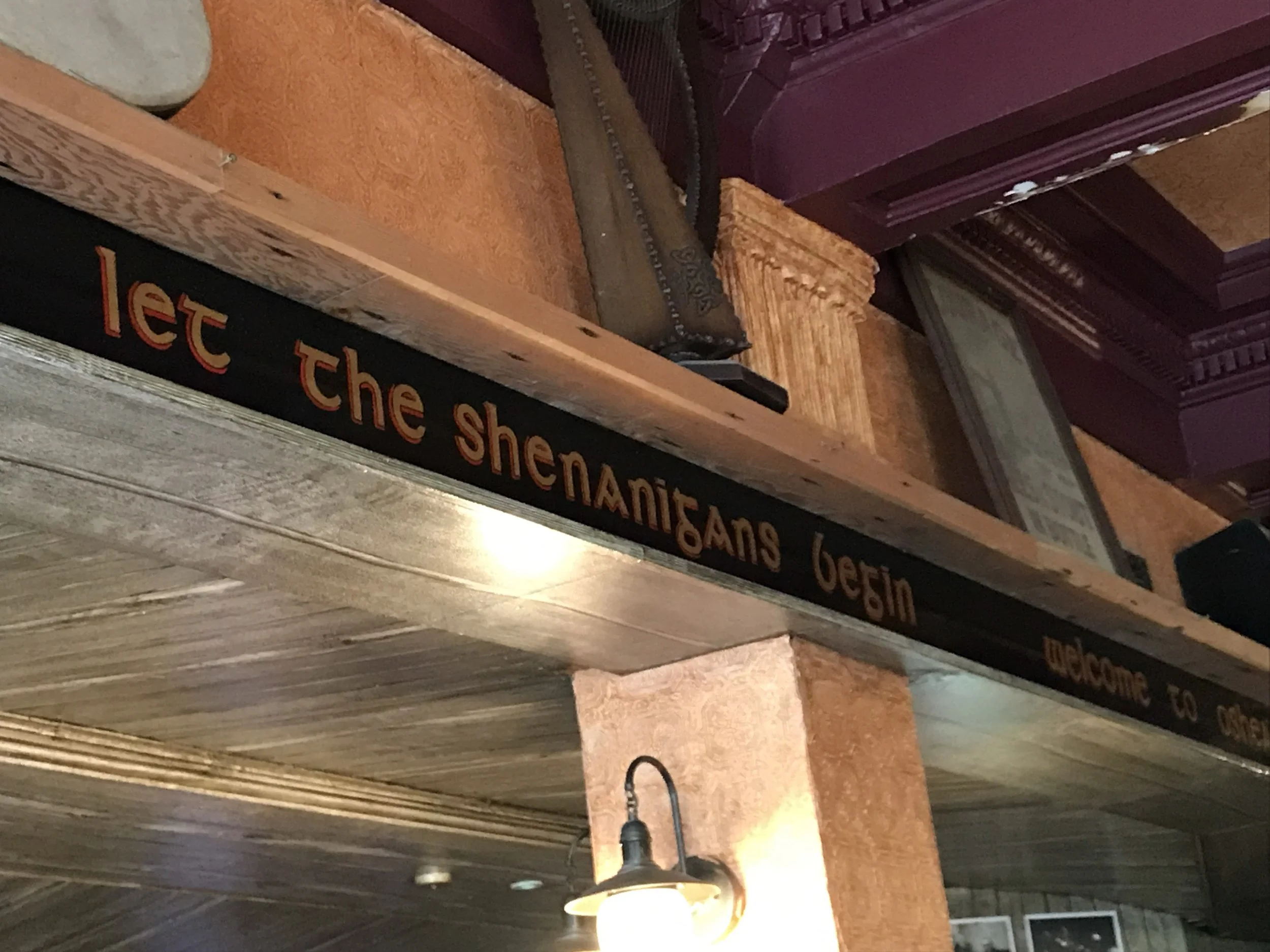 A painted sign inside O'Shea's reading 'let the shenanigans begin'.