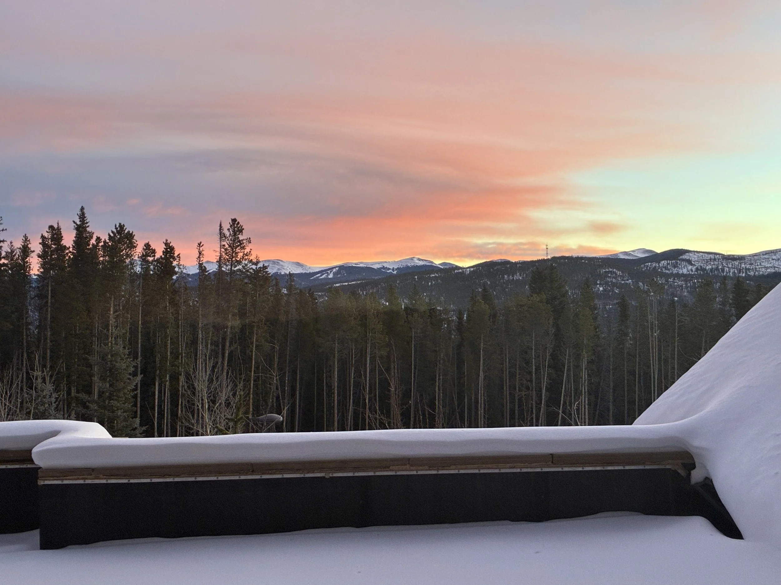 Pink sunset over snowy mountain peaks, seen from the balcony.