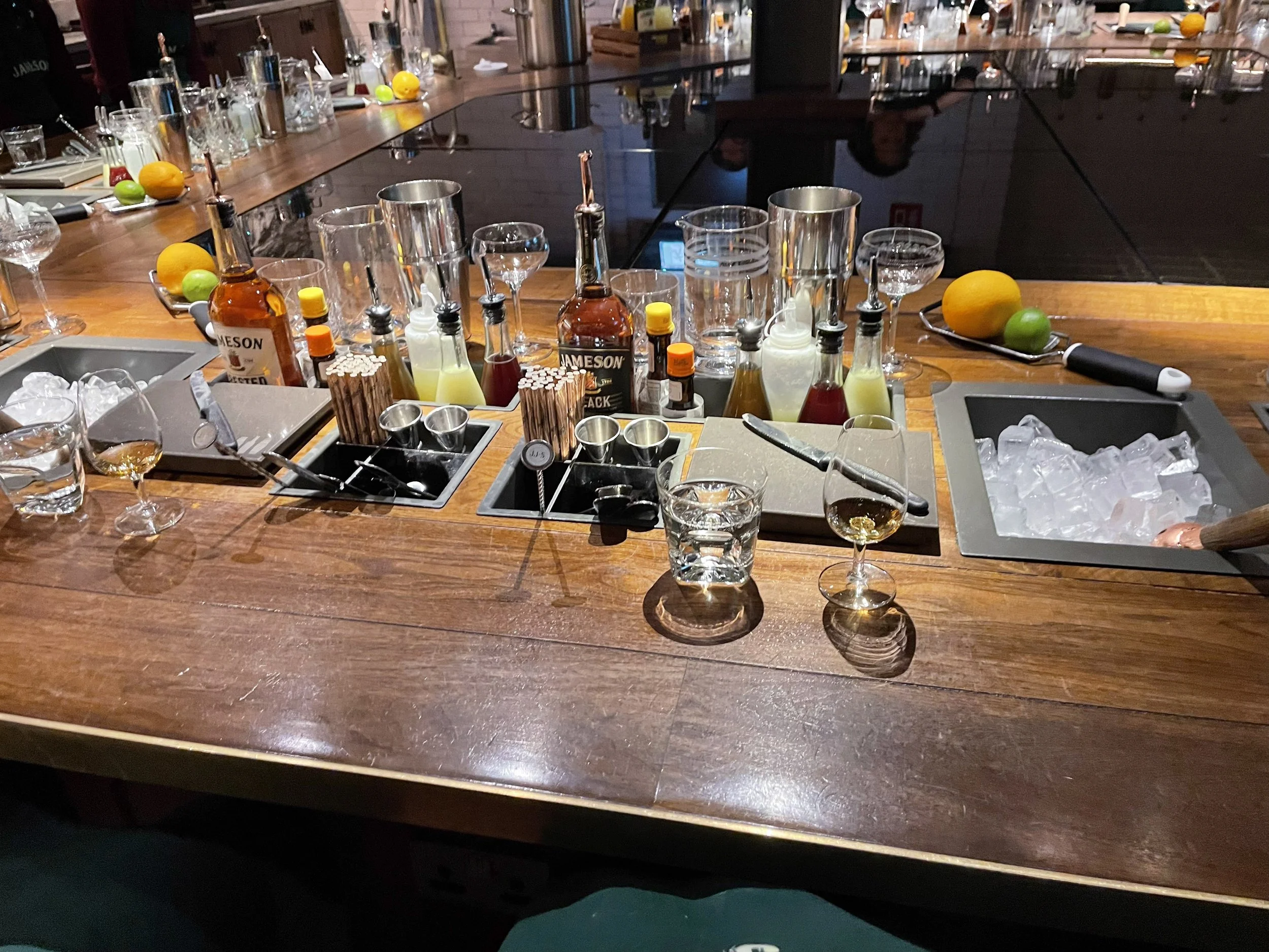 The cocktail class bar station with bottles, citrus, and tools.