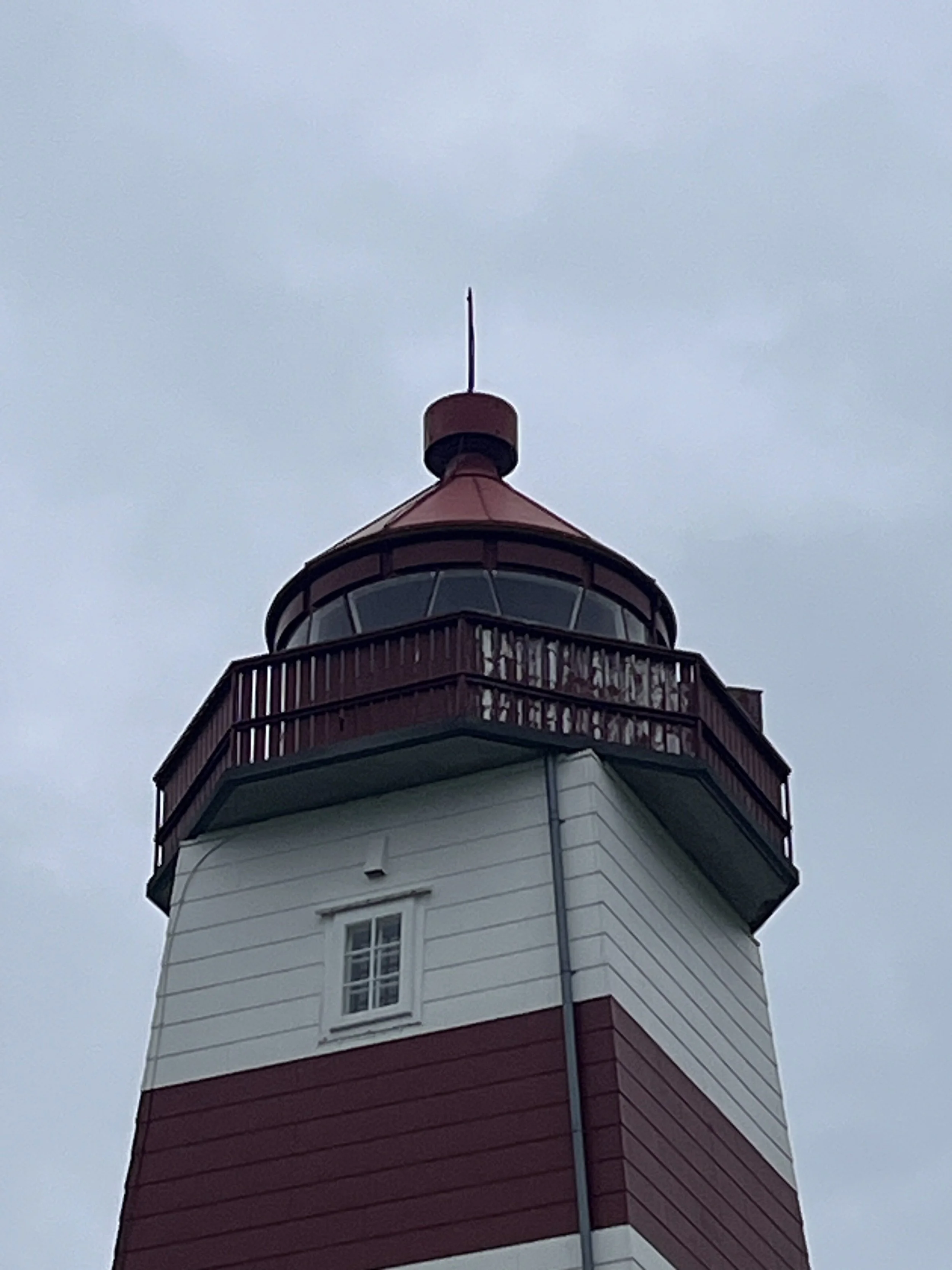 A lighthouse lantern against the sky on the coast.
