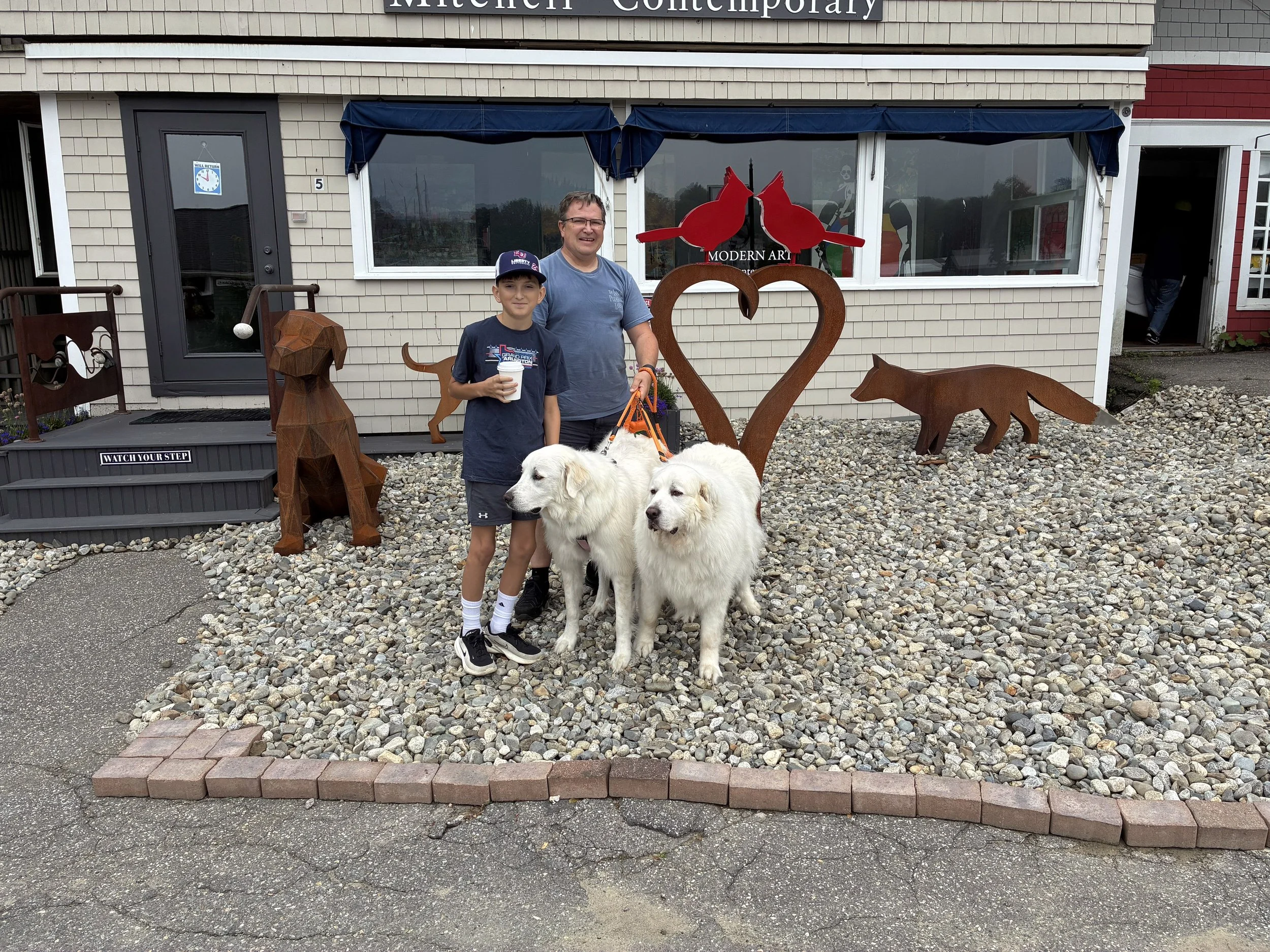 Posing with the dogs outside a gallery, among the metal sculptures.