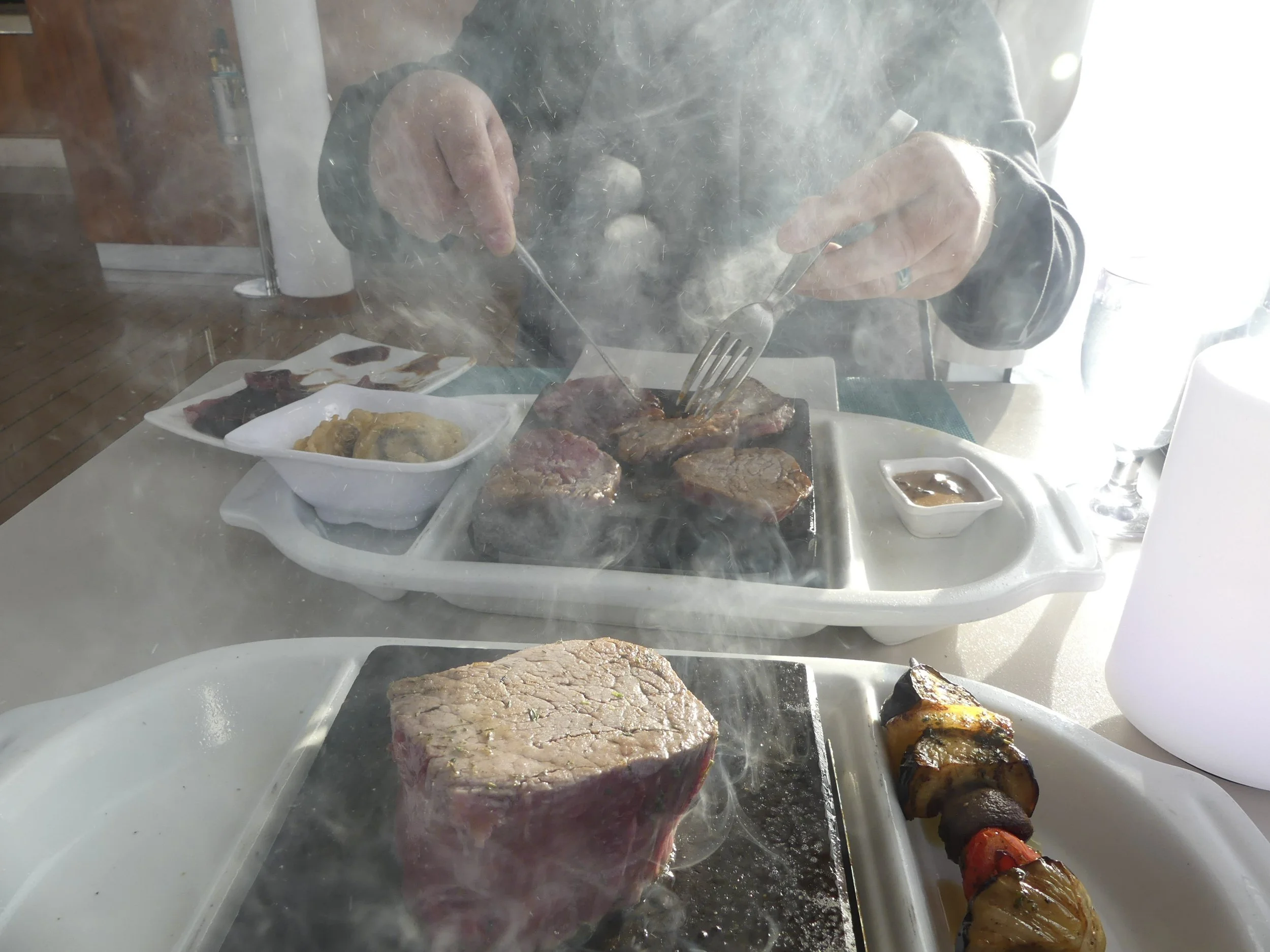 Dinner aboard — a hot-stone steak, still sizzling.