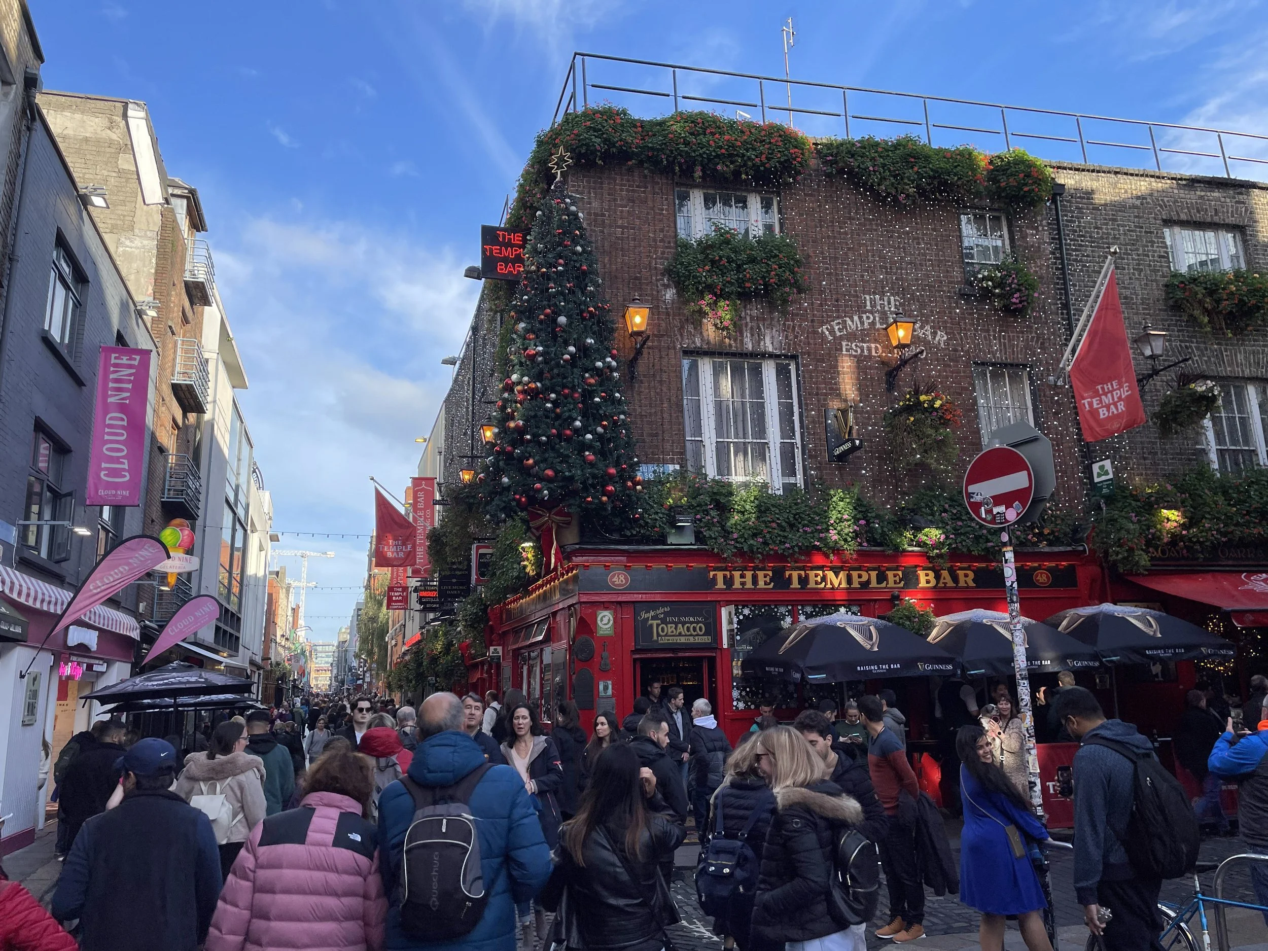 The Temple Bar pub decorated with Christmas lights, crowds outside.