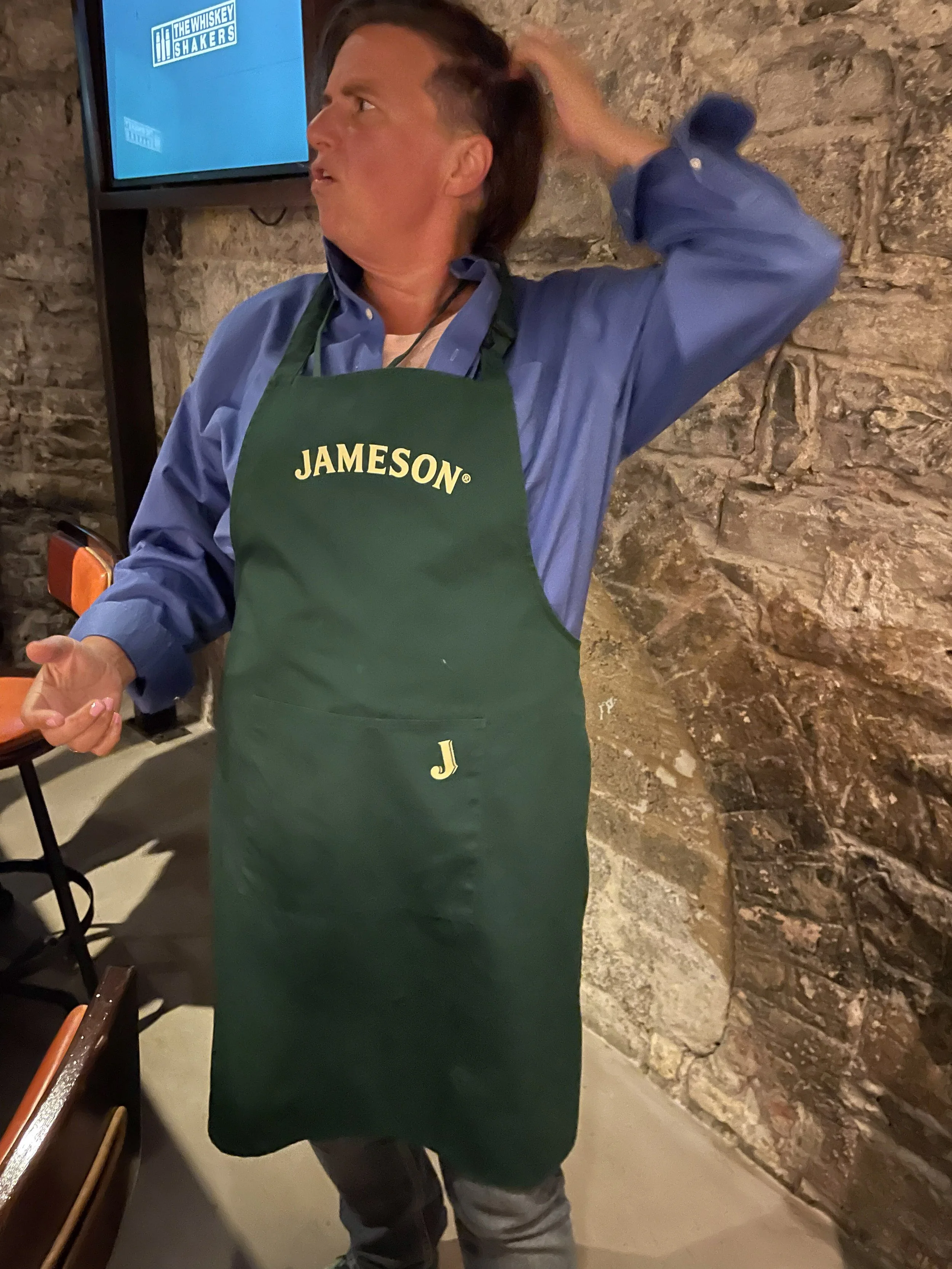 The traveler in a green Jameson apron at the cocktail class.