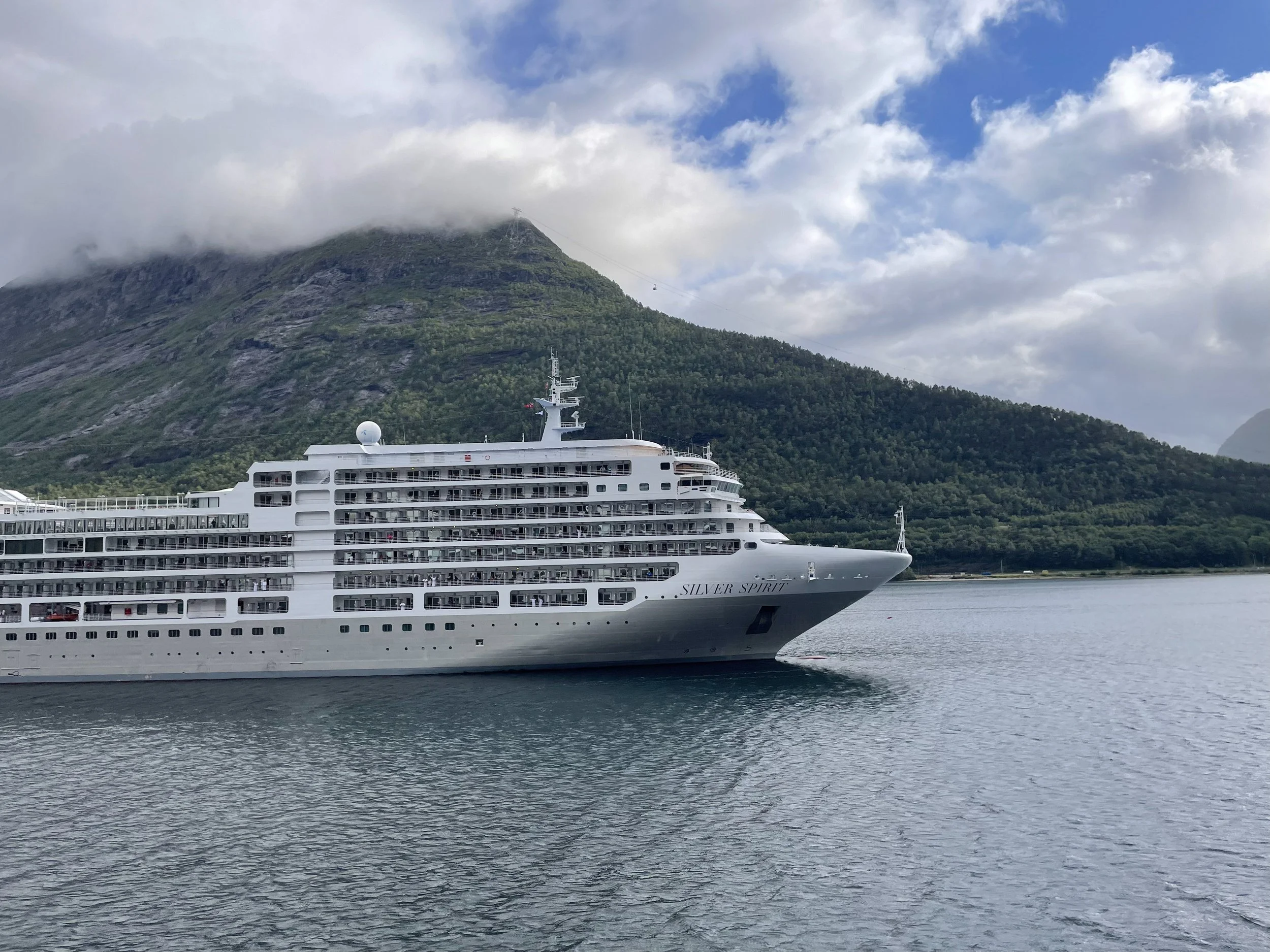 Silver Dawn at dock against a forested mountainside.