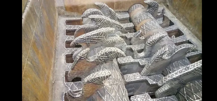 Twin shredder shafts with interlocking teeth and patterned hardfacing weld deposits