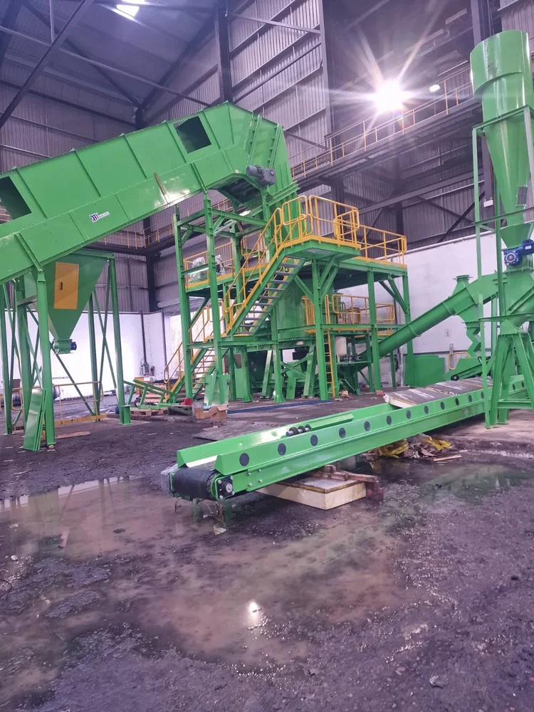 Green conveyors and multi-level steel access platforms with yellow handrails during installation
