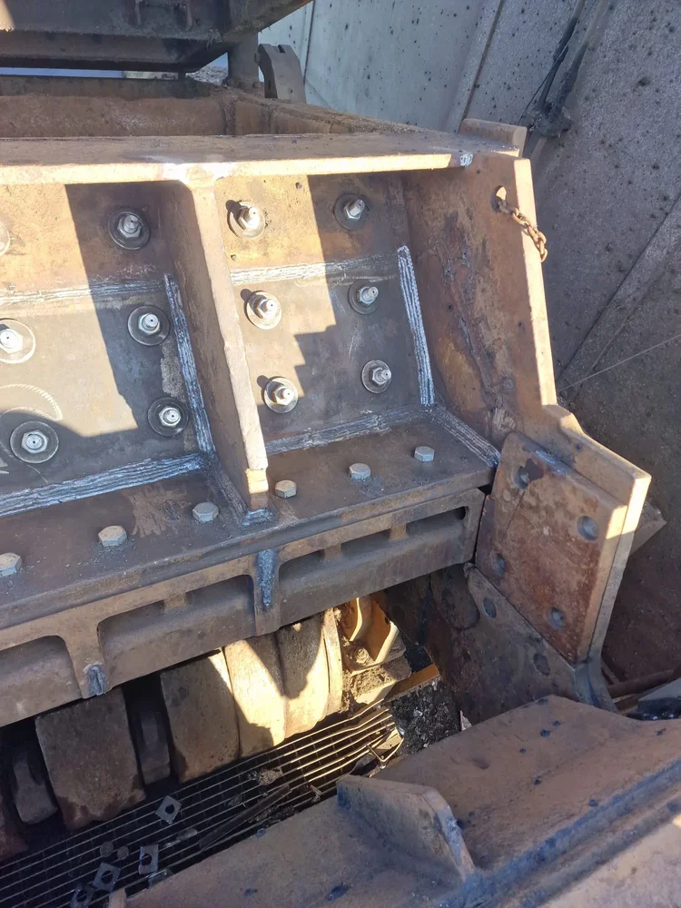 Steel machine housing with bolted plates and repaired welded joints