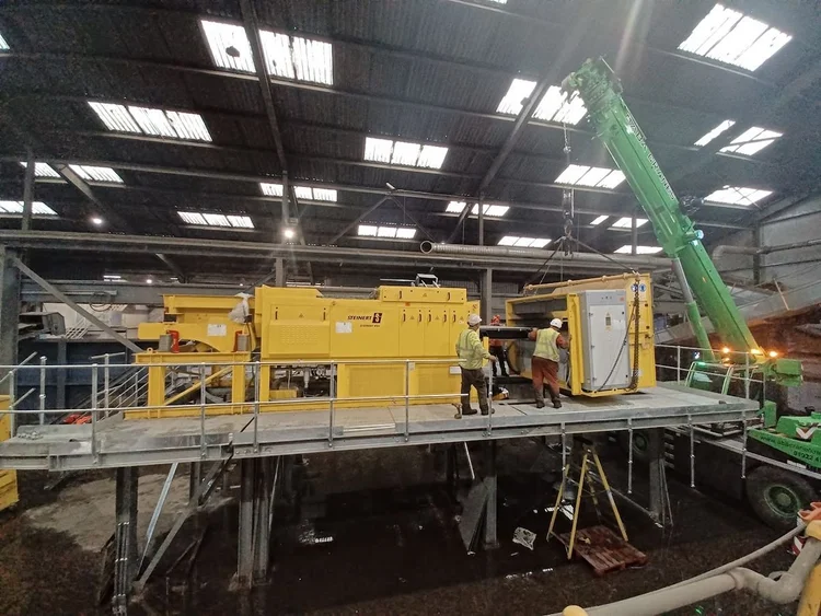 Crane lifting a separator unit onto a raised platform during an equipment installation