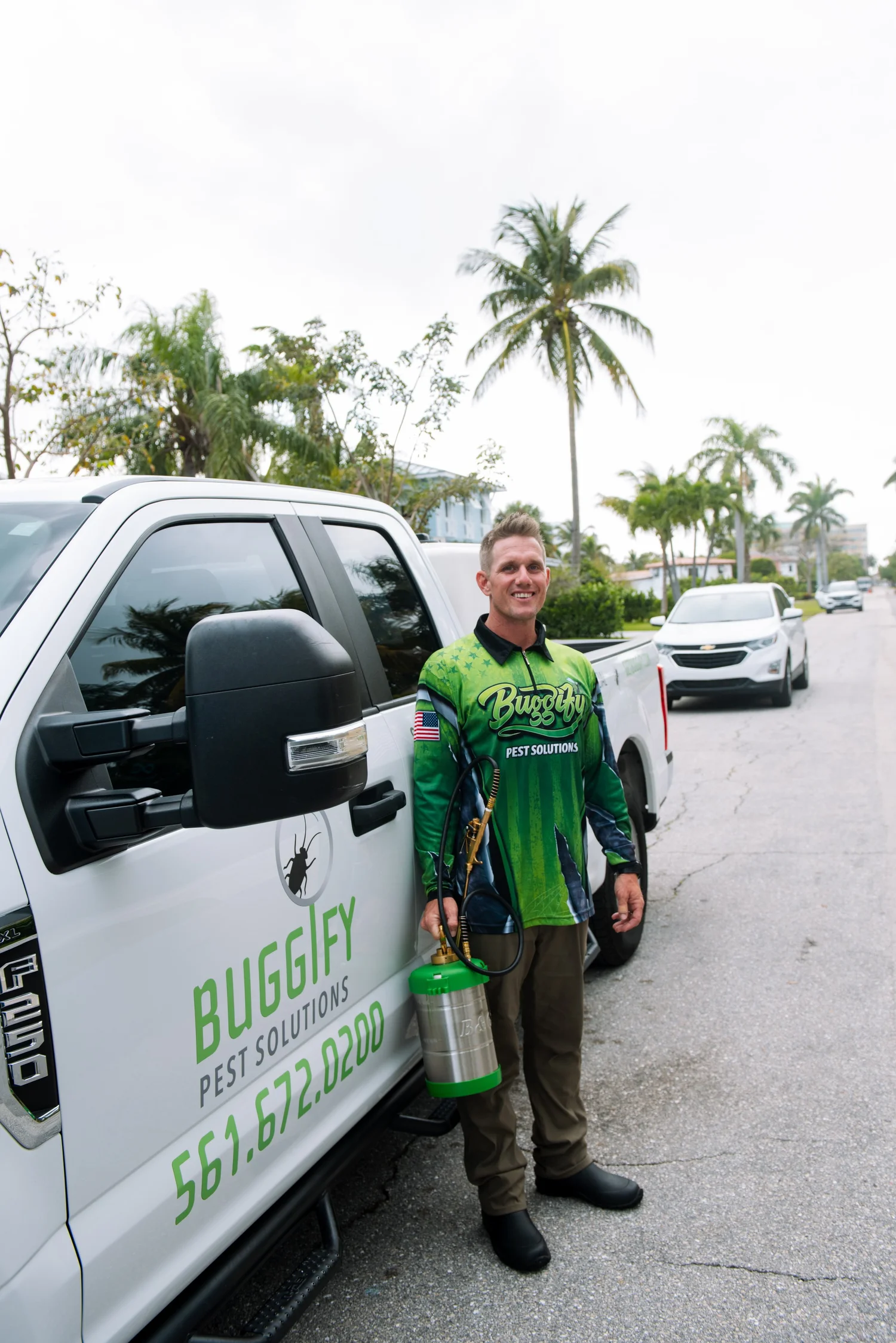 Buggify technician standing beside the branded Buggify truck on a street