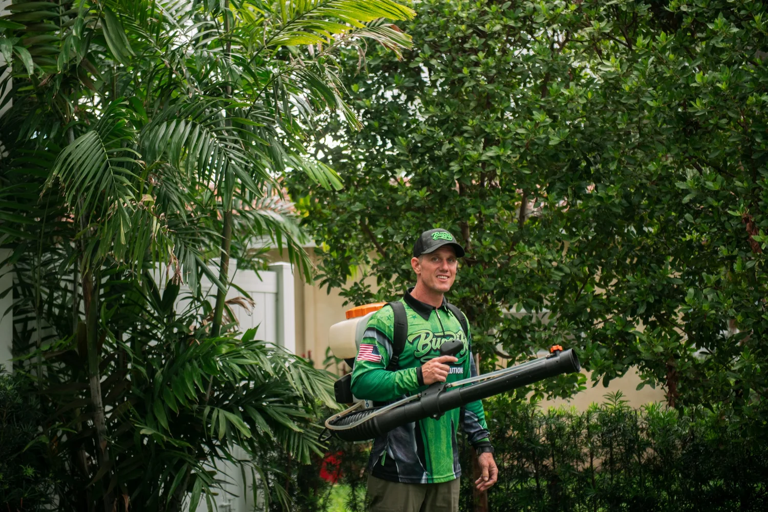 Buggify technician smiling with a mist-blower among palms
