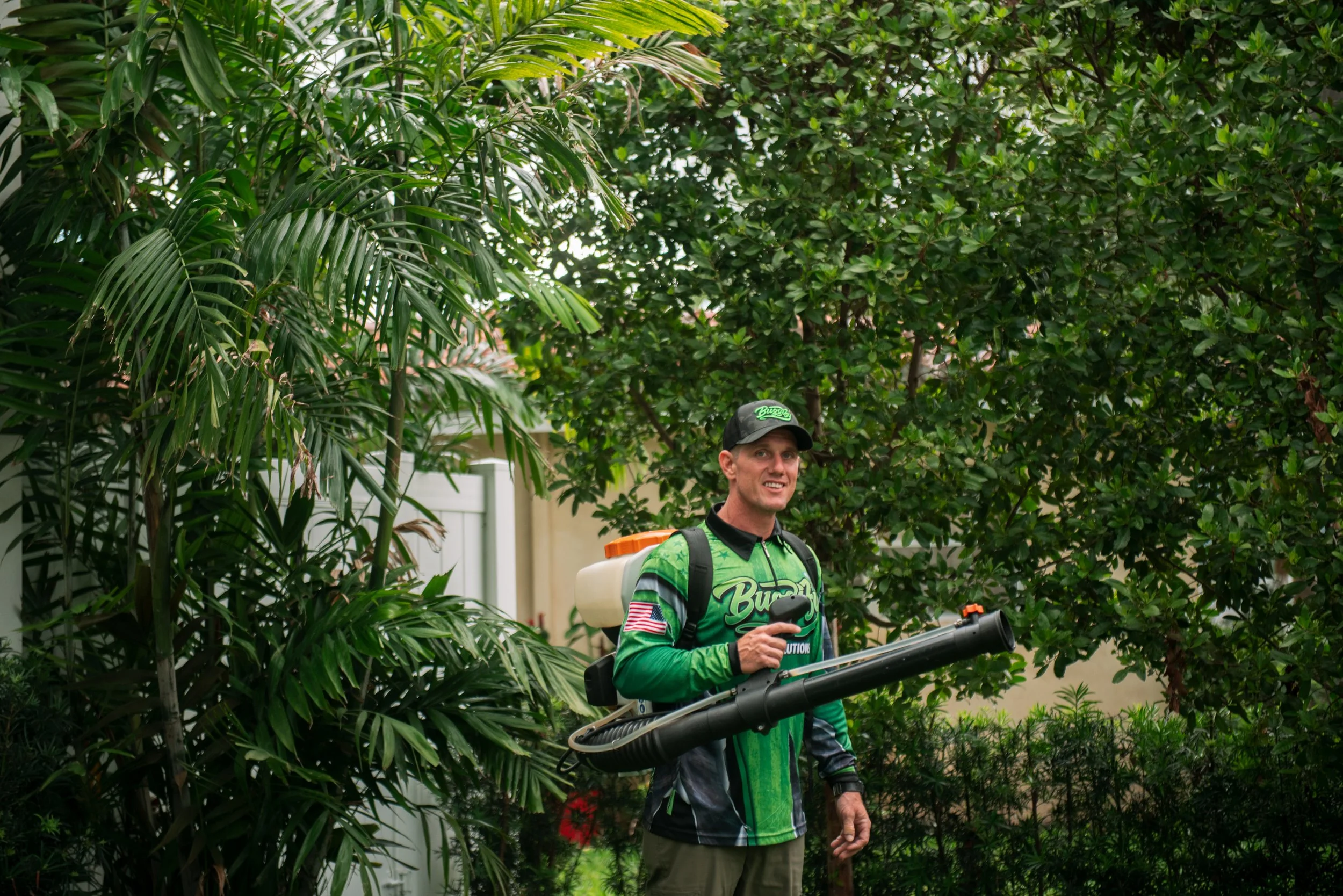 Buggify technician smiling with a mist-blower among palms