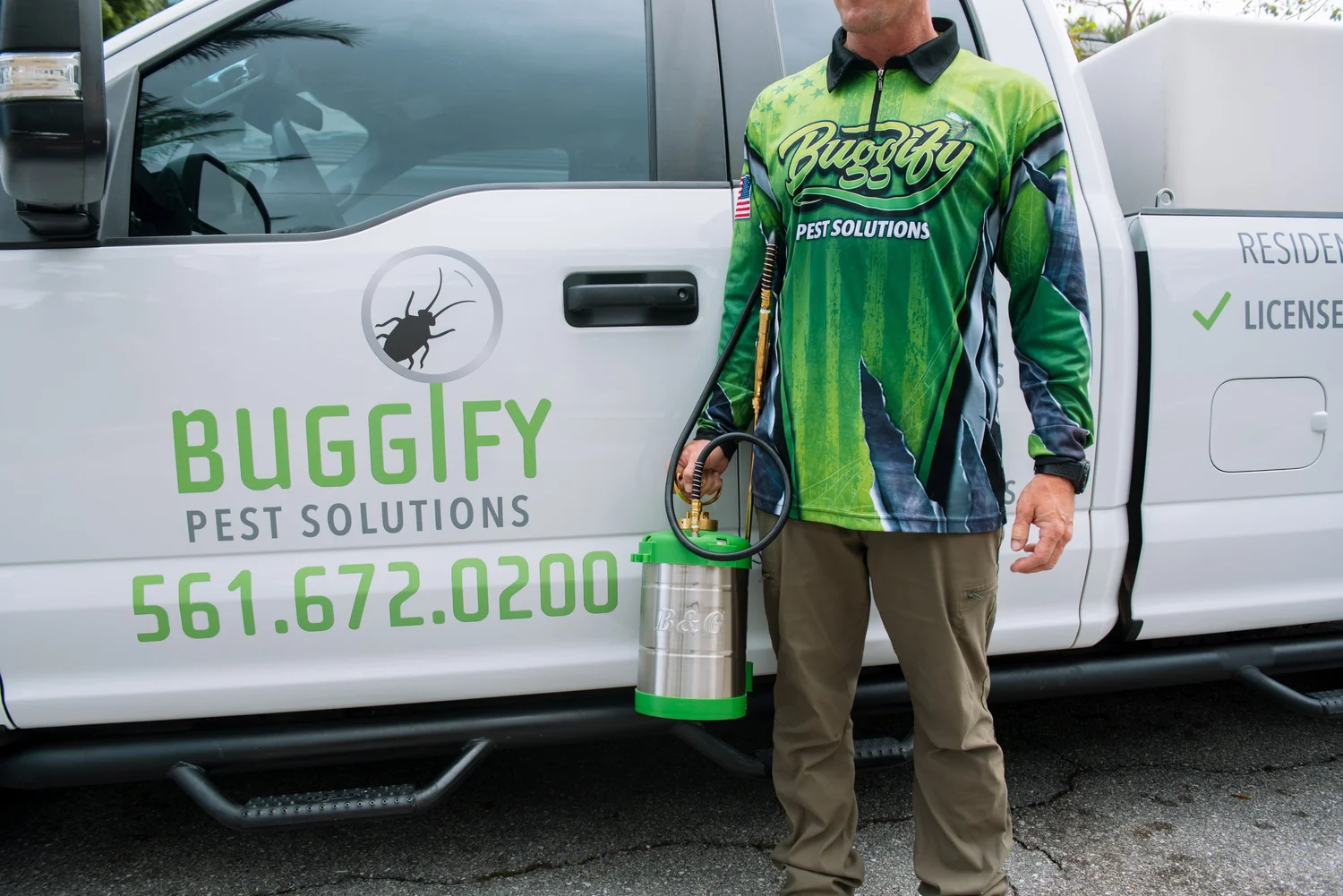 Buggify technician with a hand sprayer beside the branded Buggify truck door