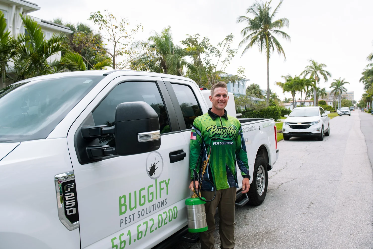 Buggify technician standing beside the branded Buggify truck on a palm-lined street