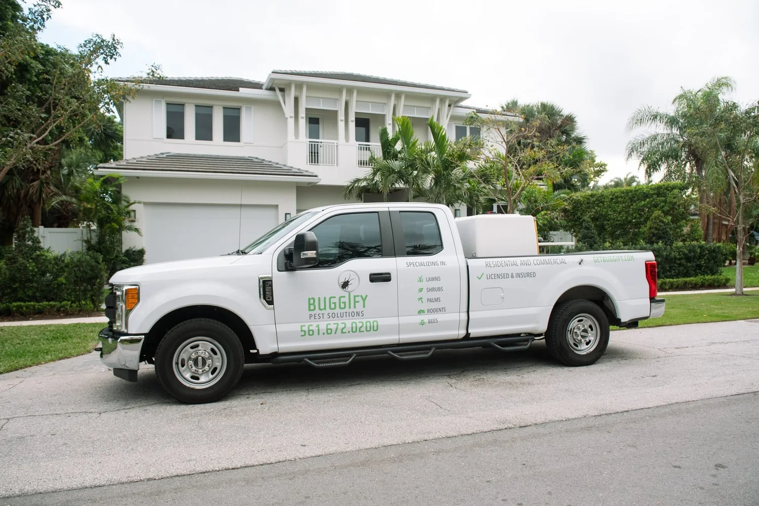 Branded Buggify truck parked in front of a two-storey white home