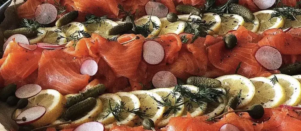 Platter of smoked salmon with lemon, dill, cornichons and radish