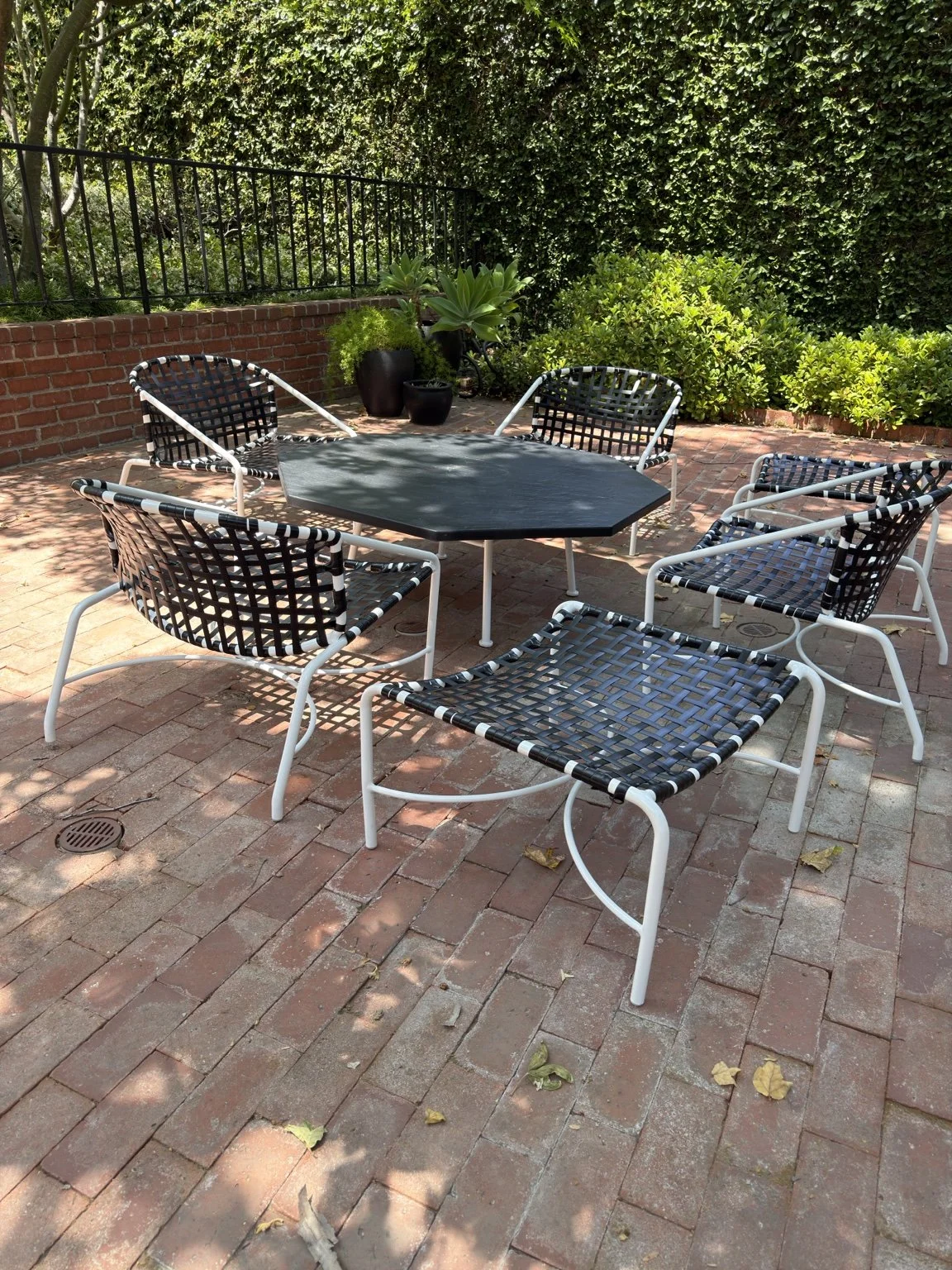 Restored outdoor dining furniture on a brick patio at a Pasadena home