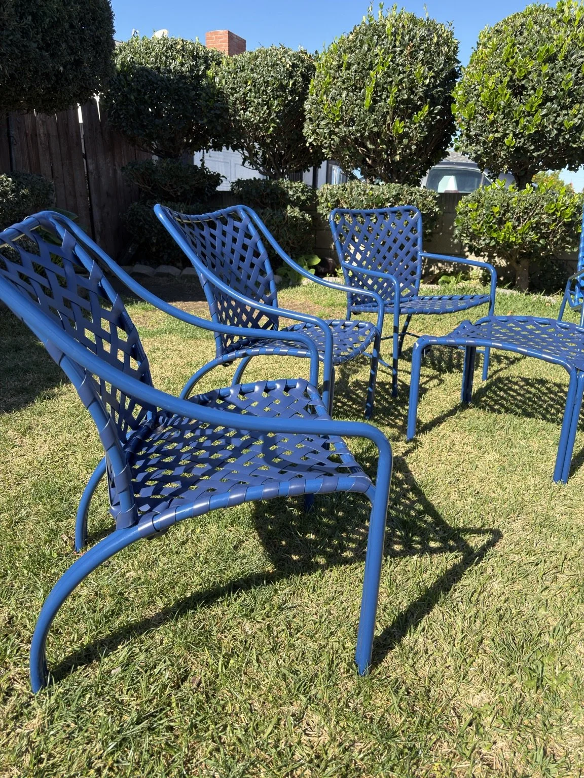 Blue patio chairs with woven vinyl straps after restoration in Pasadena