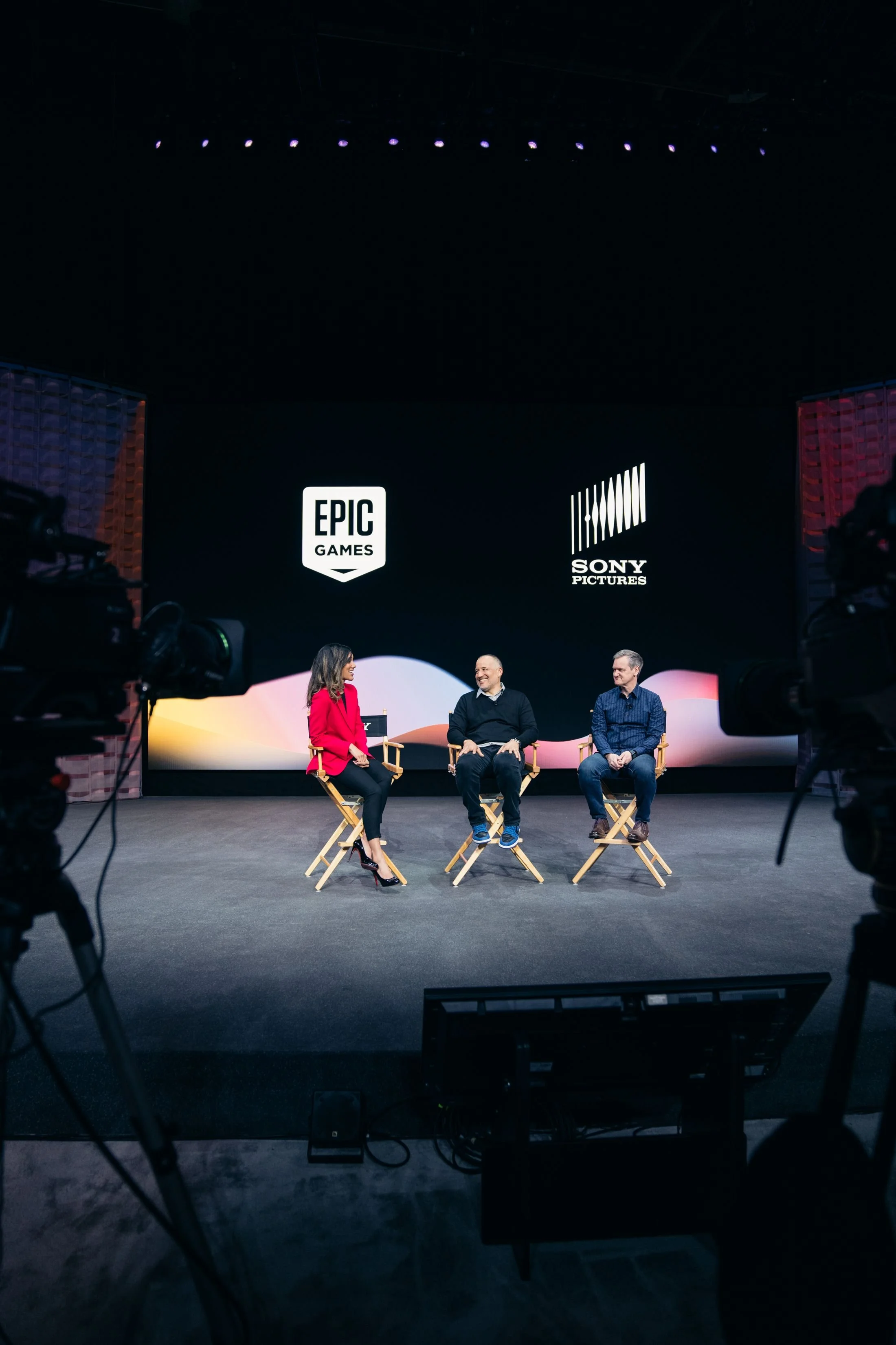 Dionna Chambers moderating a panel with Epic Games and Sony Pictures signage behind her