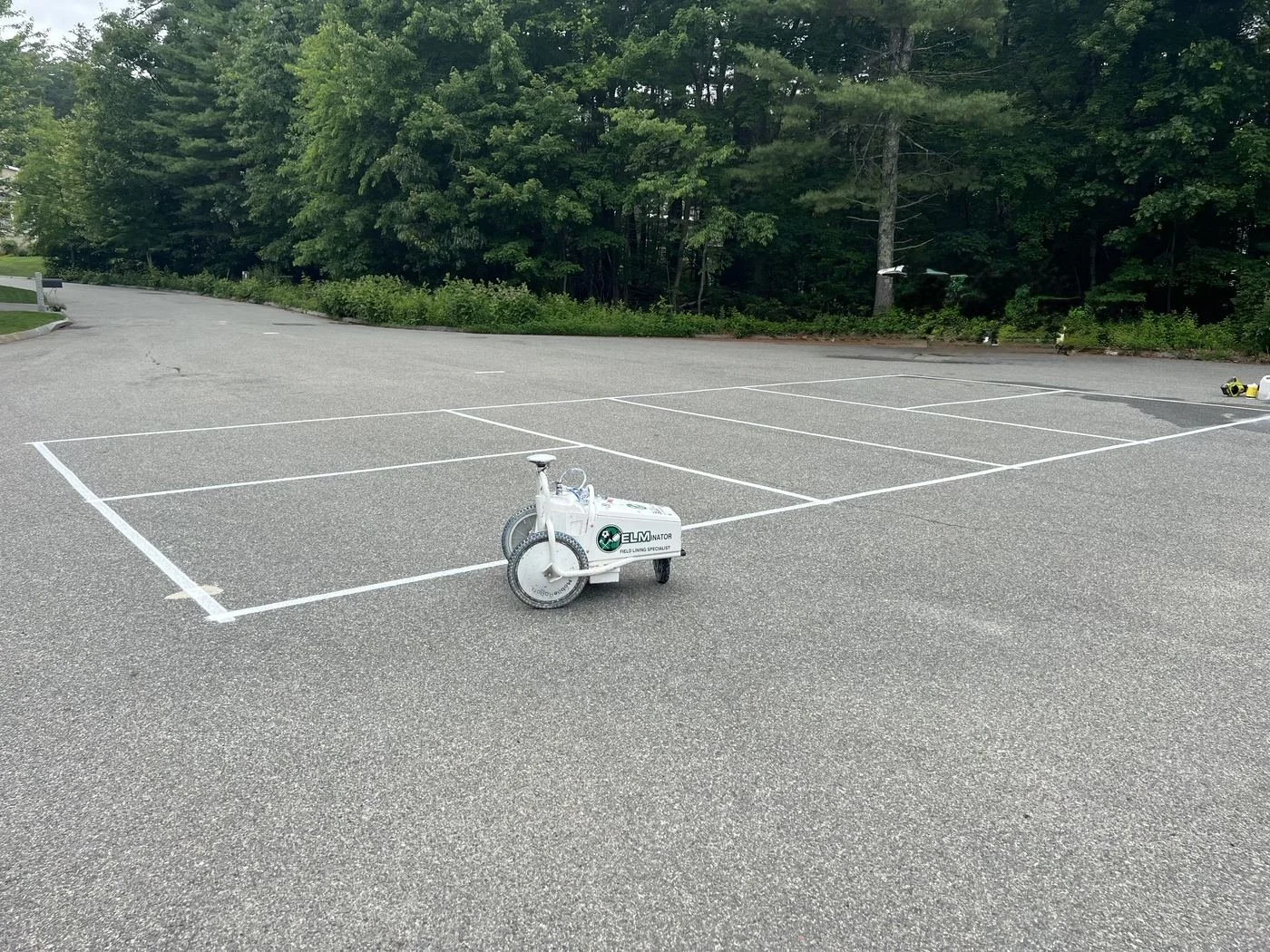 Elmscape robotic field liner painting court lines in a parking lot