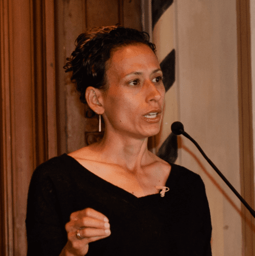 Thalia González speaking at a lectern.