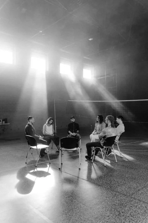 People seated in a facilitated circle, in conversation.