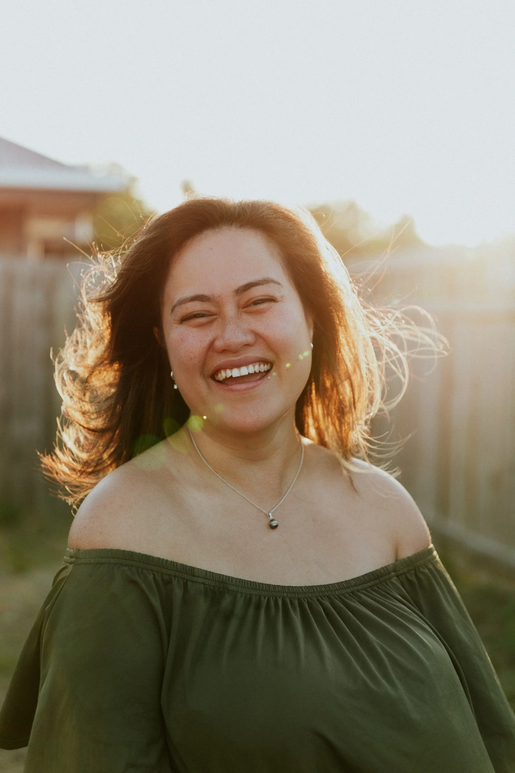 Mariana Tana, founder of Legacy, Love & Learning, laughing in her backyard at golden hour