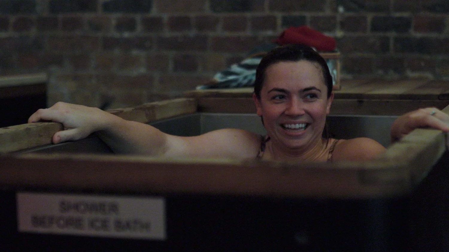 A smiling participant in a guided cold plunge at the London Recalibrate & Restore day