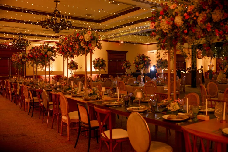 Boda de Sharon y Josh: salón con arreglos florales colgantes e iluminación cálida
