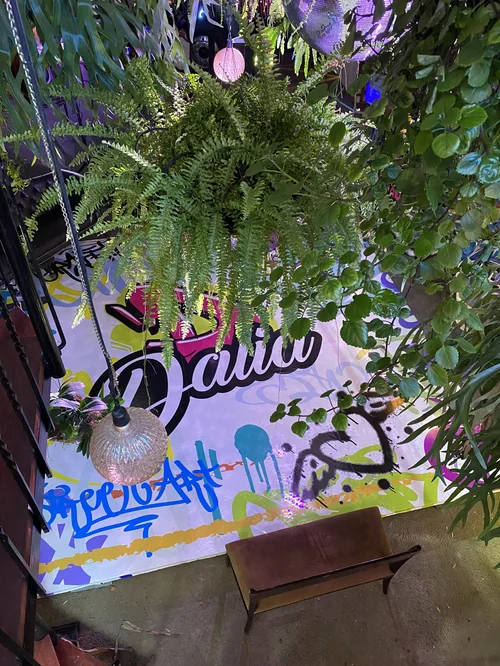 Letrero de neón con el nombre Dalia rodeado de plantas