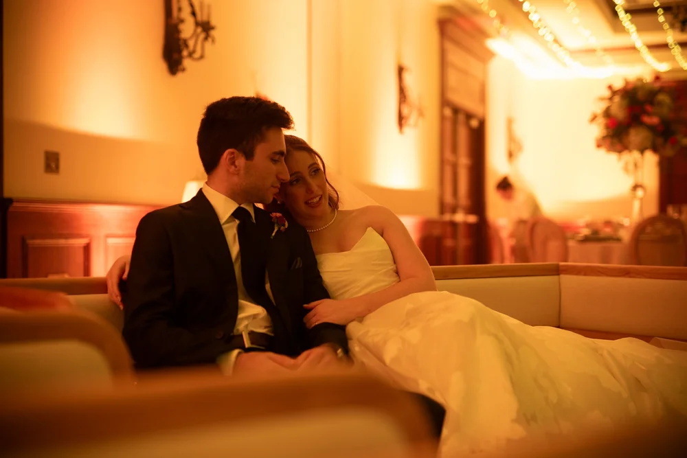 Sharon y Josh sentados en un sofá del salón con iluminación cálida