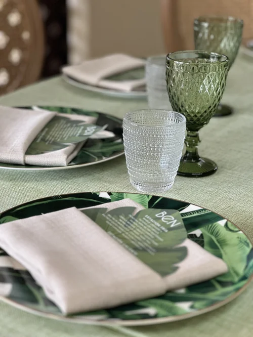 Puesto de mesa con plato de hojas de mano de tigre, copa verde y mantel verde