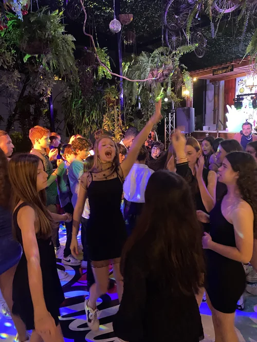 Jóvenes bailando bajo las plantas colgantes del patio